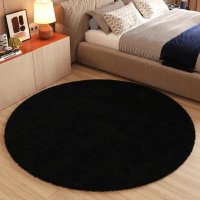 A bedroom scene with a bed, nightstand, and a round rug.