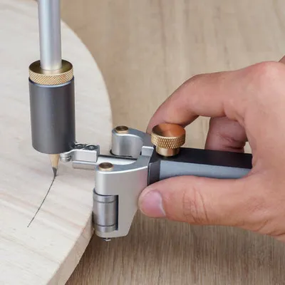 A hand is using a woodworking scribing tool to draw a line on a piece of wood.