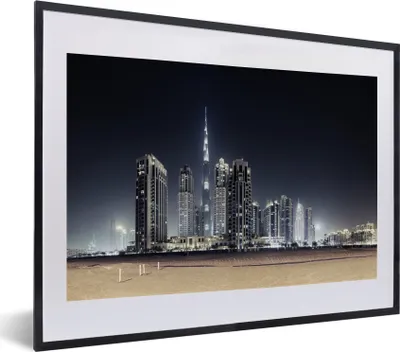 Produktbild von MuchoWow® MuchoWow® Gerahmtes Poster Der Burj Khalifa erhellt den Himmel über Dubai mit anderen Wolkenkratzern 40x30 cm - Poster mit zchwarzem Bilderrahmen - Bilderrahmen - Poster im Rahmen
