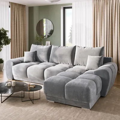 A modern living room with a large sectional sofa, coffee table, and curtains.