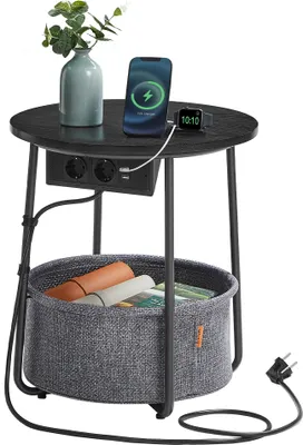 A round side table with a built-in power strip and USB ports, a storage basket, and decorative items on top.