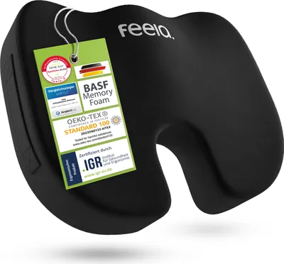 A black orthopedic seat cushion with several certification tags attached.