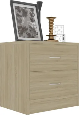 A close-up view of a wooden dresser with two drawers, decorated with a framed picture and a candle holder.