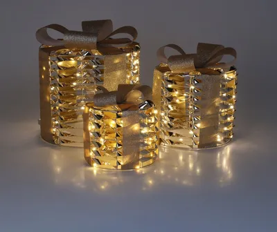 Three illuminated gift boxes with gold ribbon.