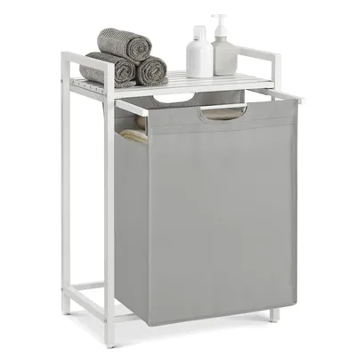 A laundry basket with a shelf on top, containing towels and soap dispensers.