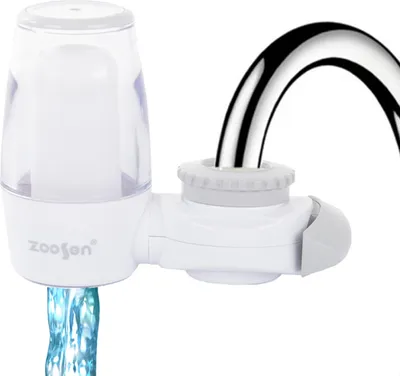A close-up of a white faucet water filter attached to a chrome faucet, with water flowing out.