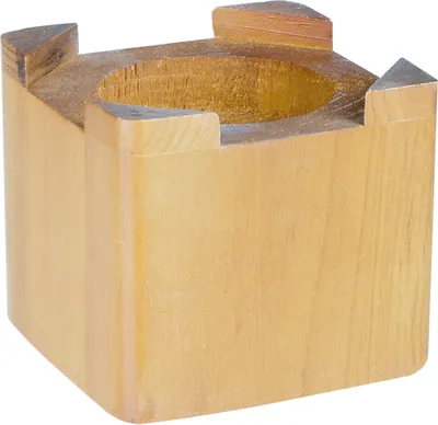 A wooden block with a circular cutout on top, supported by four corner pieces.