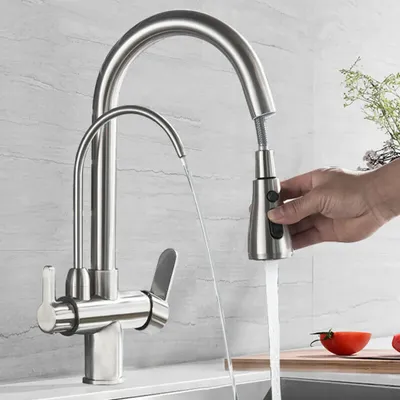 A hand is shown operating a kitchen faucet, with water flowing from both spouts.