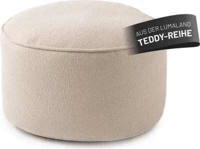 A close-up studio shot of a round, beige beanbag ottoman.