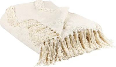 A folded beige throw blanket with fringes.