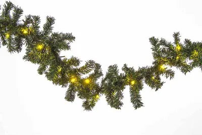 A garland of artificial pine branches with small yellow lights, displayed against a white background.