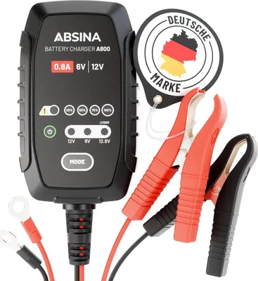 A black battery charger with red and black clamps, and a circular German brand sticker.