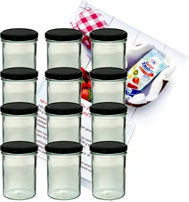 A set of glass jars with black lids, arranged in rows, with a recipe booklet and a packet of jelly powder in the background.