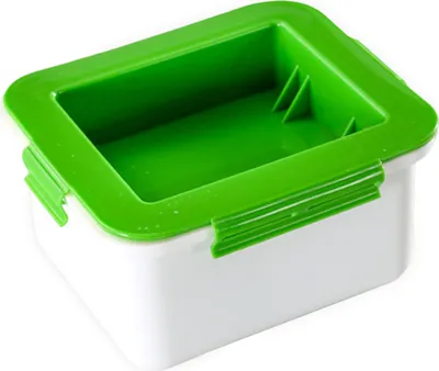 A white and green tofu press.