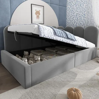A child's bed with the storage compartment open, revealing stored items like teddy bears and blankets.
