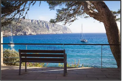 Produktbild von Wallario Wandbild Einsame Bank am Meer - Spanien im Sommer, Größe: 61 x 91,50 cm, Poster mit schwarzem Aluminiumrahmen