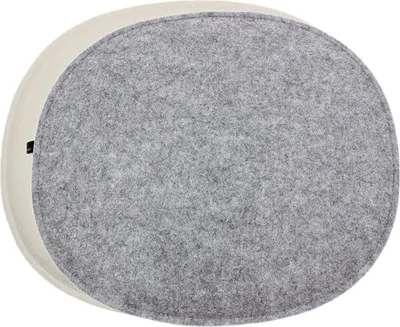 A top-down view of an oval-shaped cushion with a gray felt top and a cream-colored side.
