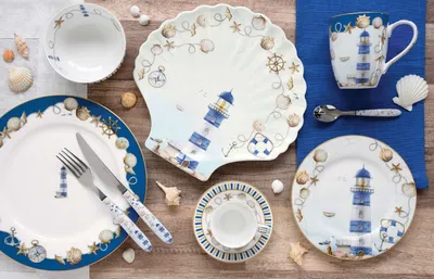 A collection of nautical-themed tableware arranged on a wooden surface.