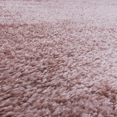 A close-up view of a pink shaggy rug.