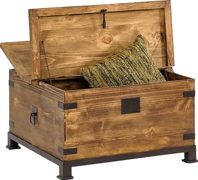 A wooden chest with a pillow inside, resting on an iron base.