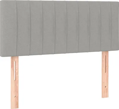 A plain studio shot of a headboard with wooden legs.
