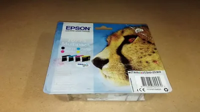 A package of Epson ink cartridges with a cheetah image on it, placed on a wooden surface.