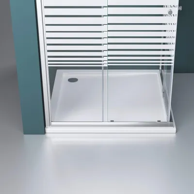 A close-up view of a modern shower enclosure with a sliding door and a white shower tray.