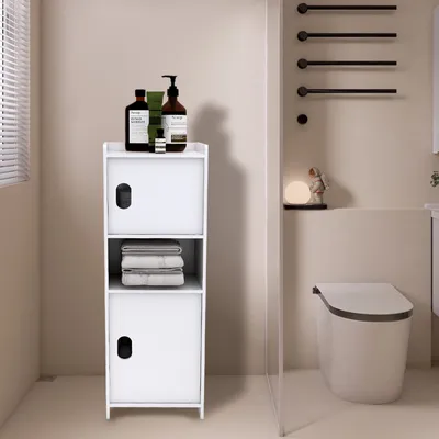 A white bathroom cabinet with bottles on top, next to a toilet.