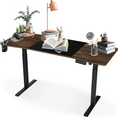 A height-adjustable desk with various office and decorative items on its surface.