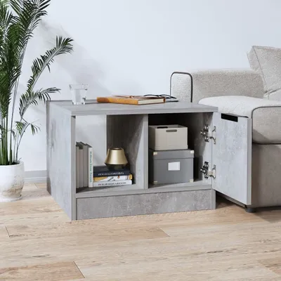 A modern living room setting with a side table next to a sofa, featuring a plant and books.