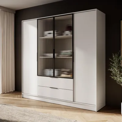 A white wardrobe with glass doors and drawers, set against a dark wall and a light-colored rug.