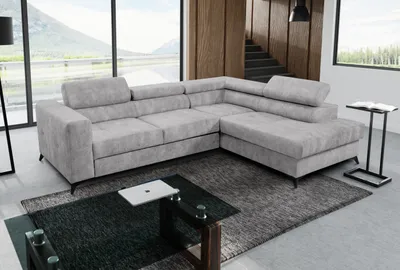 A modern living room with a large sectional sofa, coffee table, and a rug.