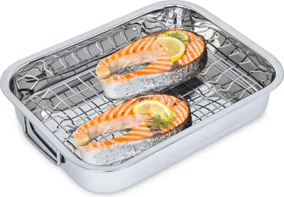 Two salmon steaks with lemon and dill in a roasting pan with a rack.