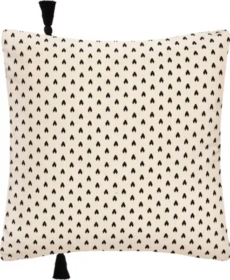 A cushion cover with a black heart pattern on a beige background, with black tassels on two corners.