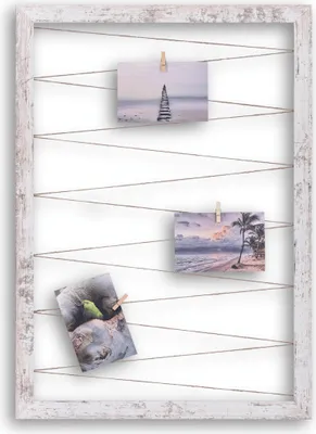 A rustic white wooden frame with strings and clothespins holding up three small photographs.