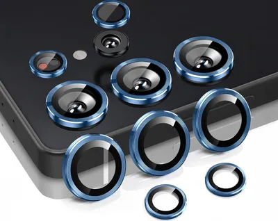 A collection of camera lens protectors arranged on a dark surface, possibly a phone.