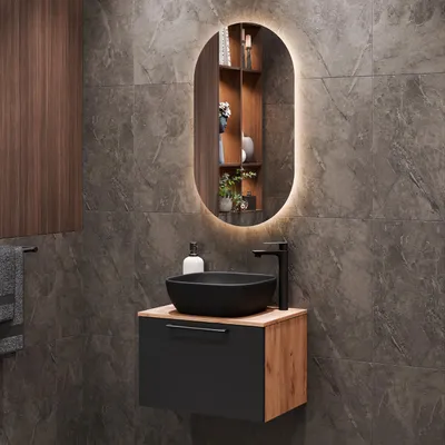 A modern bathroom vanity with a black sink and faucet, set against a dark tiled wall.
