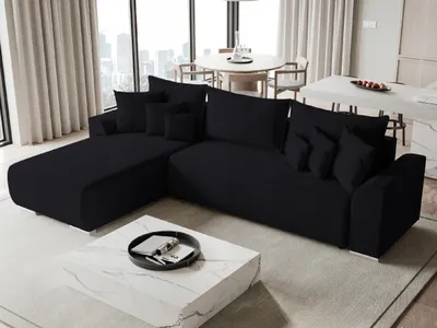 A modern living room with a black sectional sofa, a marble coffee table, and large windows with sheer curtains.