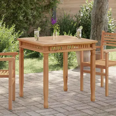A wooden table and chairs set in an outdoor garden setting.
