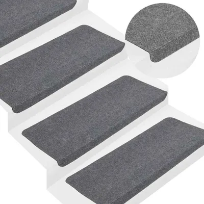 Several grey stair mats are arranged on white steps.