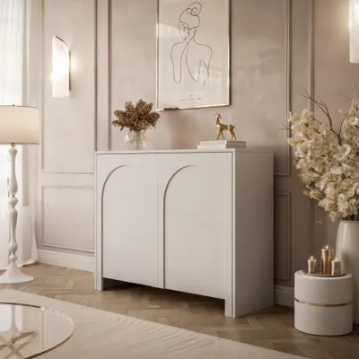 A modern living room with a white cabinet, floor lamp, and decorative items.