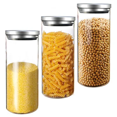 Three glass storage jars with stainless steel lids, filled with different food items.