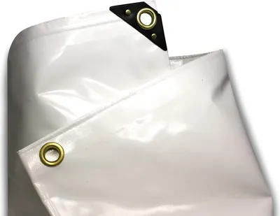 A close-up view of a white PVC truck tarp, showing reinforced corners with grommets.