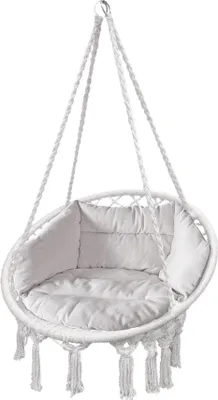 A white hanging chair with cushions and tassels, suspended by ropes.