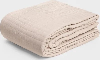 A folded beige blanket is shown on a light gray background.