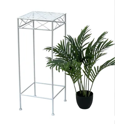 A white metal plant stand next to a potted green plant.