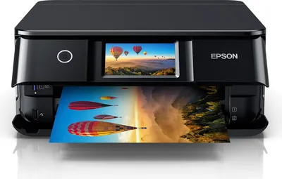 A black Epson Expression Photo XP-8700 Multifunktionsdrucker is shown from the front, printing a colorful image.