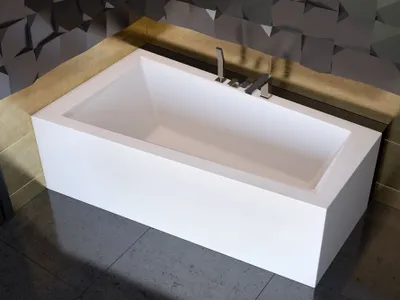 A modern white bathtub with a chrome faucet, set against a textured dark gray wall and a tan border.