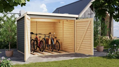 A wooden bike shed with its doors open, showing two bicycles inside, set in a garden with a house in the background.