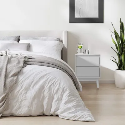 A bedroom scene with a bed and a nightstand.